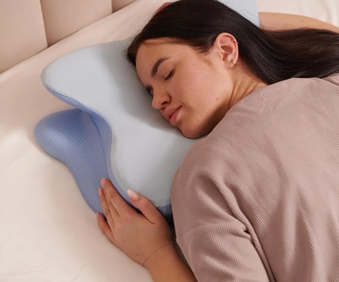 Woman sleeping on her side on the butterfly-shaped pillow